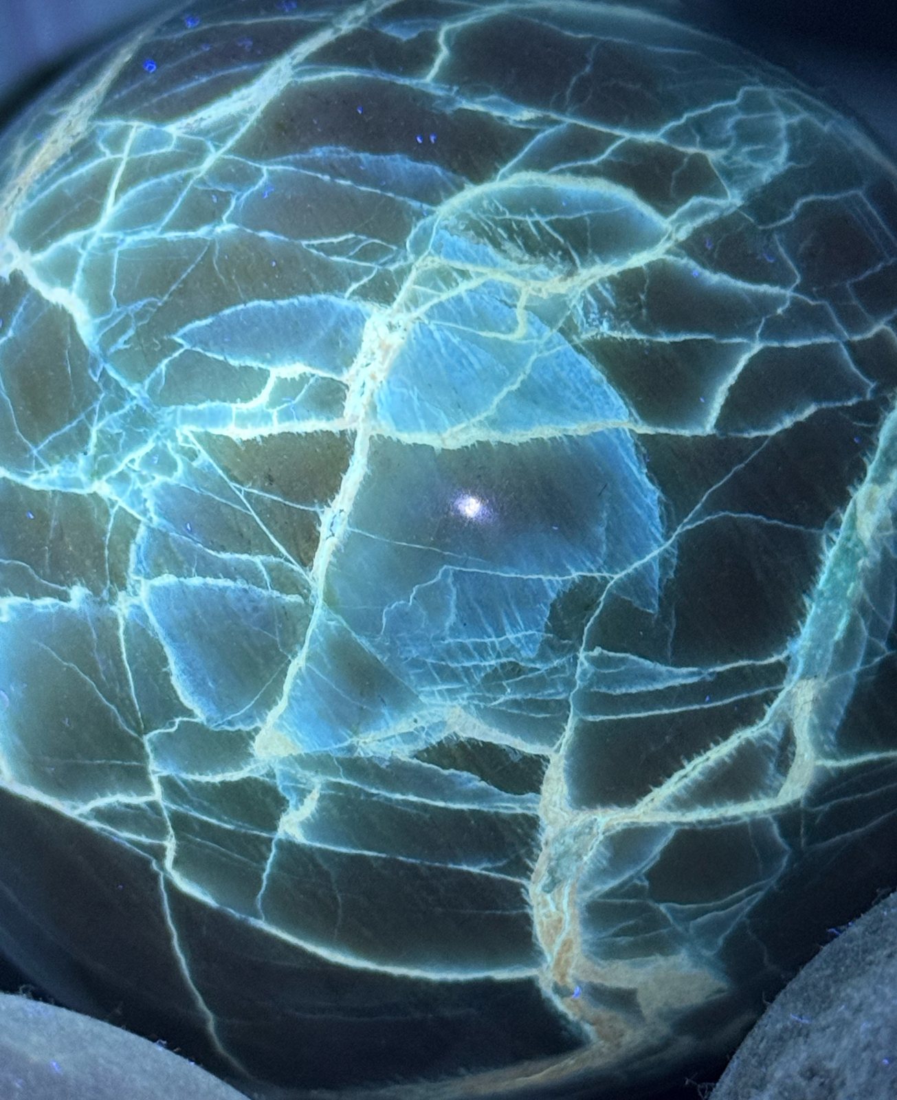 Green moonstone sphere under UV light